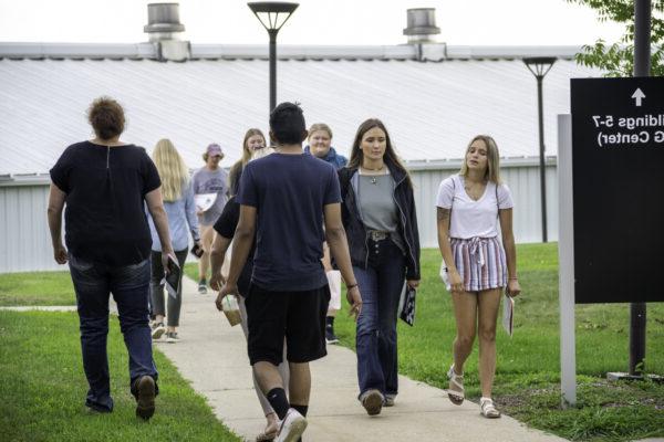 A group of people walking on a sidewalk